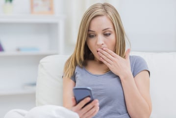 Young woman shocked looking at overdraft fees and non sufficient funds fees she was charged by her bank 