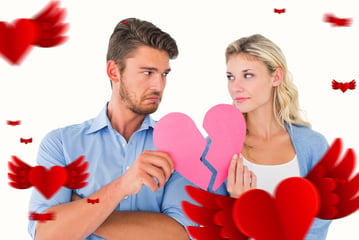 Couple holding two halves of broken heart against hearts