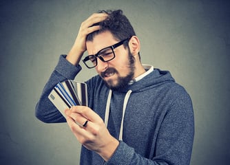 How does debt consolidation impact credit confused man with glasses and credit card debt 